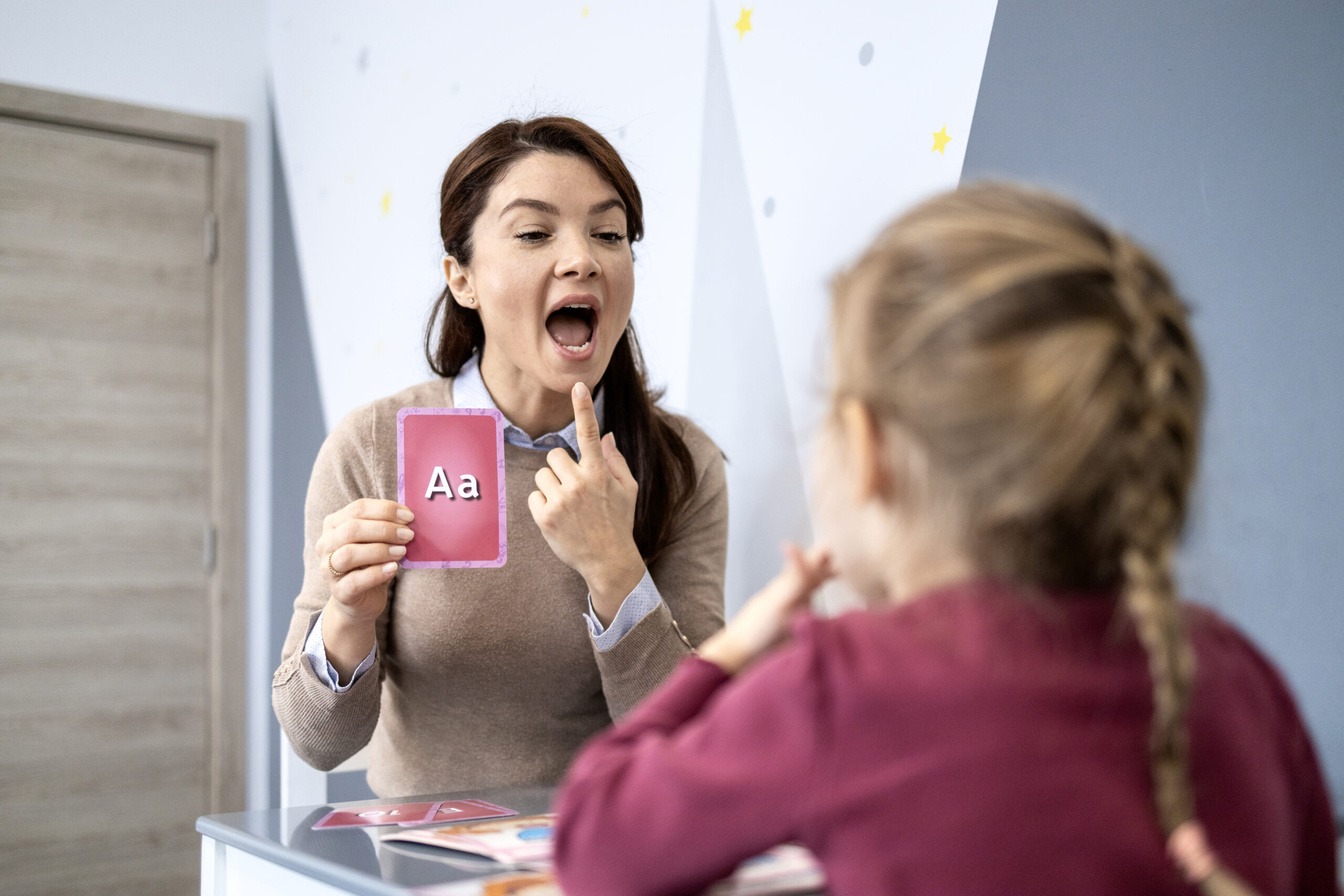 Teacher showing letter card to child